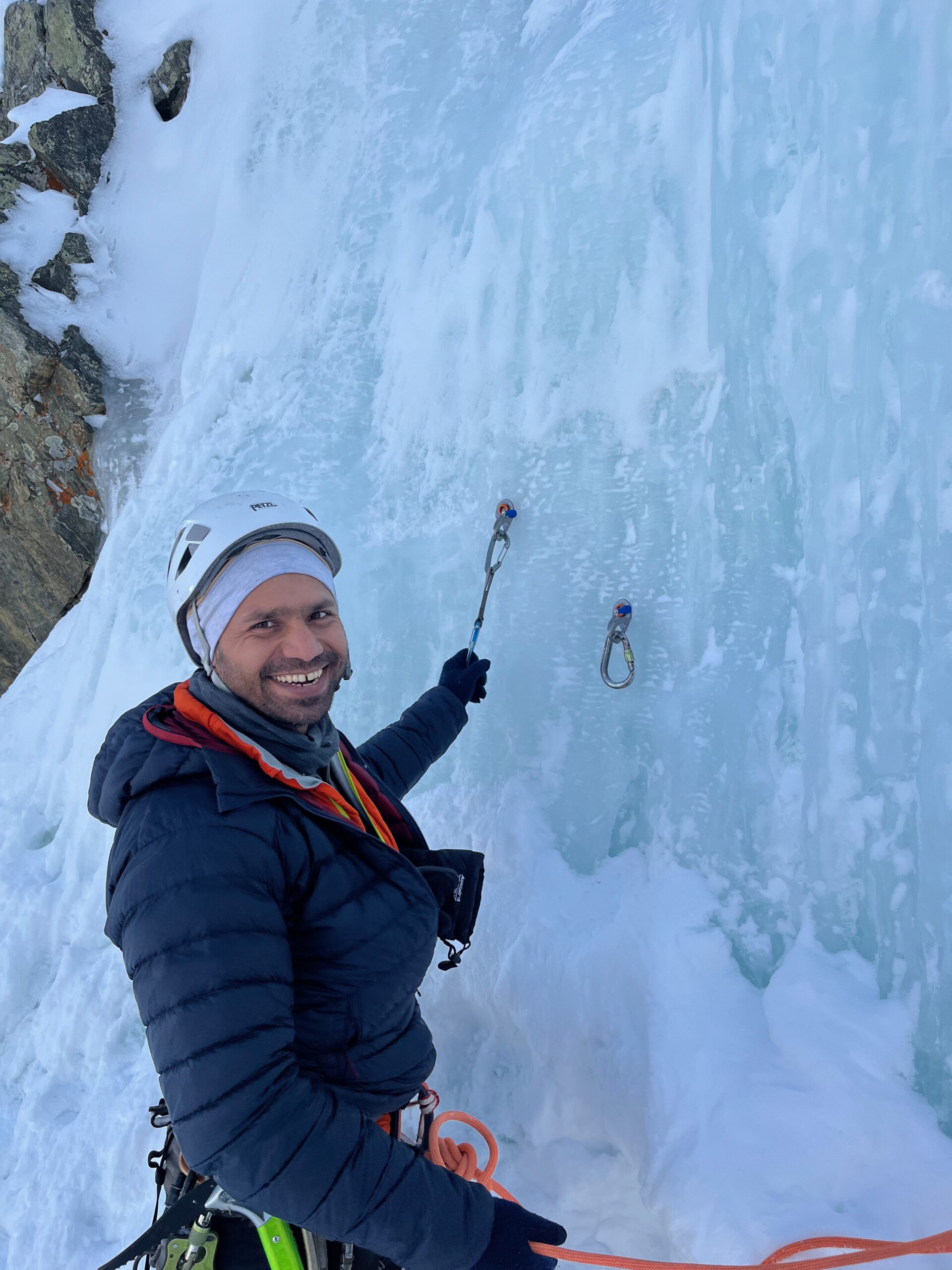 An ice climbing student learns about ice anchors at Lincoln Falls in Colorado